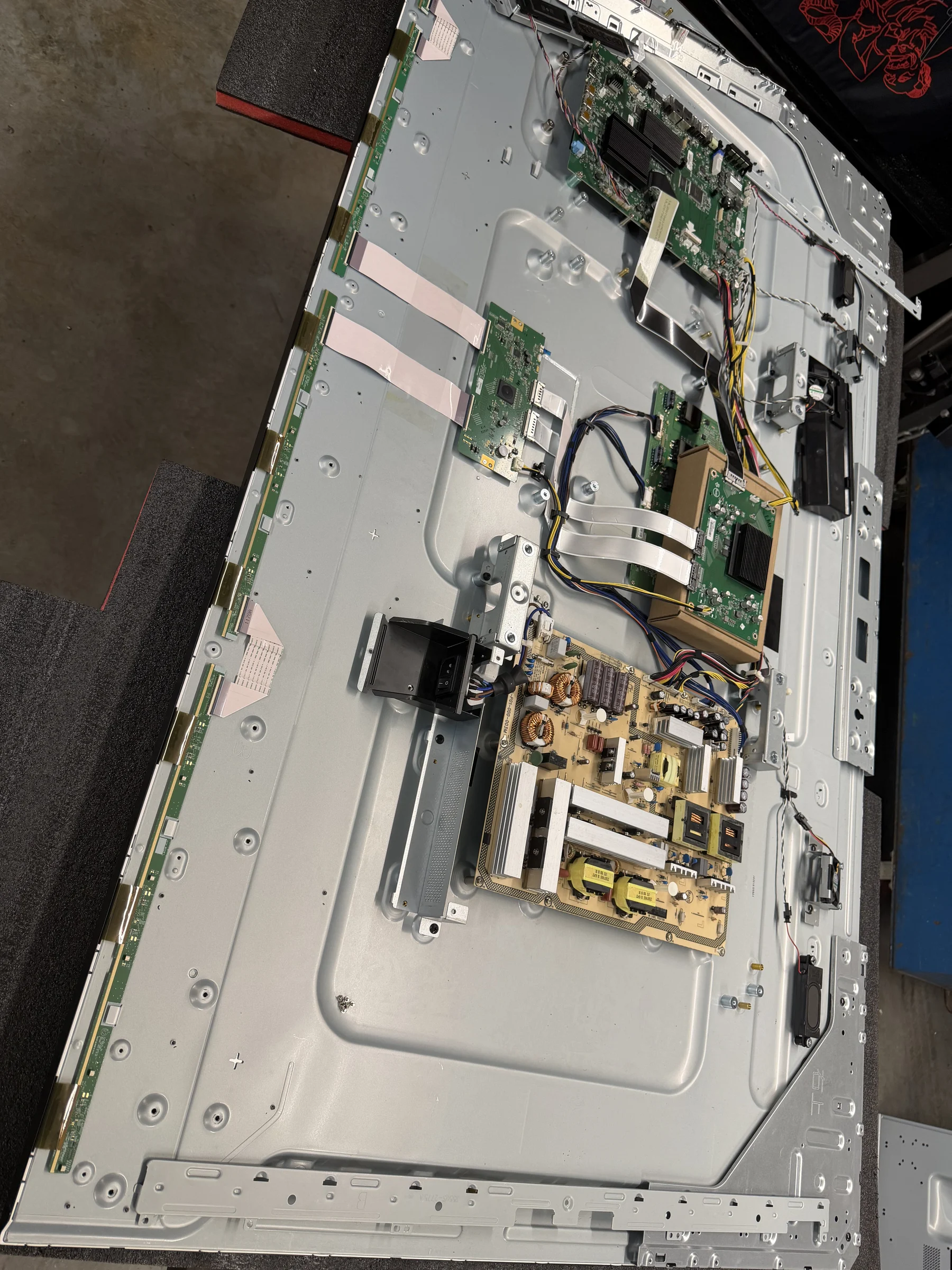 The open back of the NEC monitor showing its circuit boards, power supply, ribbon cables, and metal chassis.